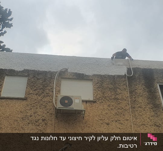 אדם על גג מורח חומר איטום לבן